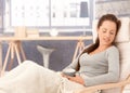 Young woman relaxing in armchair eyes closed Royalty Free Stock Photo