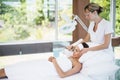 Young woman relaxing on bed while receiving facial massage Royalty Free Stock Photo