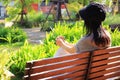 Young woman relaxing on a bench with a cup of coffee in the garden Royalty Free Stock Photo