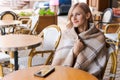 Young woman while relaxing in cafe at table on street, happy caucasian woman Royalty Free Stock Photo