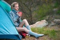 Young woman relaxing with a cup of tea near a tent against green Royalty Free Stock Photo