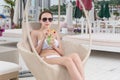 Young Woman Relaxing with Drink on Resort Patio Royalty Free Stock Photo