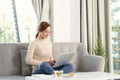 Young woman relaxing and drinking cup of hot coffee or tea using laptop computer Royalty Free Stock Photo