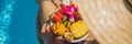 Young woman relaxing and eating fruit plate by the hotel pool. Exotic summer diet. Photo of legs with healthy food by Royalty Free Stock Photo