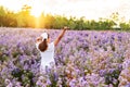 Young woman relaxing and enjoying in blooming flowers field in the morning Royalty Free Stock Photo
