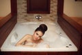 Young woman relaxing in foam jacuzzi bath spa, brunette enjoying Royalty Free Stock Photo