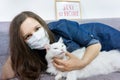 Young woman relaxing at home with pet cat. Cozy time at home. Self time and Coronavirus outbreak quarantin concept Royalty Free Stock Photo