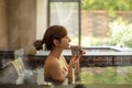 Young woman relaxing in hot spring and drinking tea Royalty Free Stock Photo