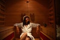 Young woman in the infrared sauna during a procedure at the spa resort center. Body care