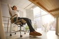 Young woman relaxing in office chair at workplace, low angle view Royalty Free Stock Photo