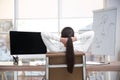 Young woman relaxing in office chair at workplace, back view Royalty Free Stock Photo