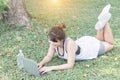 Young woman relaxing in the park, using a laptop on vacation day, Education and technology concept Royalty Free Stock Photo