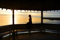 Young woman relaxing on pier on the lake at sunset. Royalty Free Stock Photo