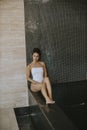 Young woman relaxing on the poolside of indoor swimming pool Royalty Free Stock Photo