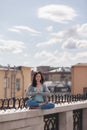 Young woman in a relaxing pose on the parapet