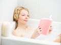 Young woman relaxing and reading a book in the bath Royalty Free Stock Photo