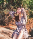 Young woman is relaxing on a rock on a Sunny Beach for Summer vacation relaxation and hapiness concept