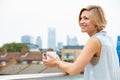 Young Woman Relaxing On Roof Terrace With Cup Of Coffee Royalty Free Stock Photo