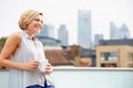 Young Woman Relaxing On Roof Terrace With Cup Of Coffee Royalty Free Stock Photo