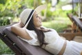 Young woman relaxing and sitting on the lounge chair looking at beautiful beach on holidays Royalty Free Stock Photo