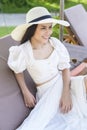 Young woman relaxing and sitting on the lounge chair looking at beautiful beach on holidays Royalty Free Stock Photo