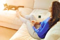 Young woman relaxing on sofa holding cup with lemon tea. Woman dreaming in living room lying on couch. Woman thinking Royalty Free Stock Photo