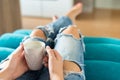 Young woman relaxing on the sofa at home, watching tv and enjoying coffee Royalty Free Stock Photo