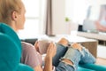 Young woman relaxing on the sofa at home, watching tv and enjoying coffee Royalty Free Stock Photo