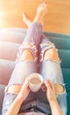 Young woman relaxing on the sofa at home, watching tv and enjoying coffee Royalty Free Stock Photo