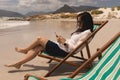 Young woman relaxing on sun lounger and using mobile phone Royalty Free Stock Photo