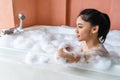 Woman relaxing and takes bubble bath in bathtub with foam Royalty Free Stock Photo