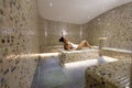 Young woman relaxing on the tepidarium bed in the spa