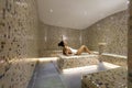 Young woman relaxing on the tepidarium bed in the spa