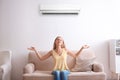 Young woman relaxing under air conditioner