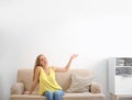 Young woman relaxing under air conditioner Royalty Free Stock Photo