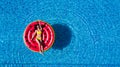 Young woman relaxing on watermelon in hotel resort pool. Top view of rich girl floating with fruit mattress drinking cocktail. Royalty Free Stock Photo