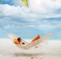 Young woman relaxing in wicker hammock on the sandy white beach on Mauritius coast and enjoying wide ocean view waves. Exotic Royalty Free Stock Photo