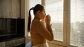 Young woman relaxing at window in morning with cup of tea or coffee. People in morning, beautiful cityscape, having break at Royalty Free Stock Photo