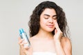 Young woman removing her makeup with a cleanser