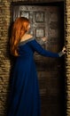 Young woman in renaissance dress open door Royalty Free Stock Photo