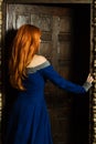 Young woman in renaissance dress open door Royalty Free Stock Photo