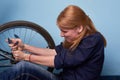 Young woman repairing a bike. pretty young girl repairing bicycle in bike shop Royalty Free Stock Photo