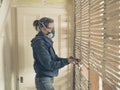 Young woman repairing wattle and daub wall