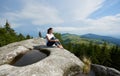 Young woman resting on a big stone in the summer day in the Carpathian mountains Royalty Free Stock Photo