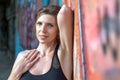 Young woman resting after doing gymnastics on the street. Portrait of fit and sporty young woman doing stretching in city