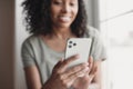 Young woman using smartphone at home. Student girl texting on mobile phone in her room. Online ommunication and tecknology concept Royalty Free Stock Photo