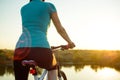 Young Woman Resting with Mountain Bike on Summer Rocky Trail and Looking at Beautiful Sunset. Travel, Sports and Adventure Concept Royalty Free Stock Photo