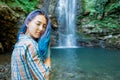 Young woman resting near the waterfall in summer.