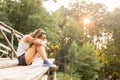 Young woman resting on a wooden bridge in jeans sneakers Royalty Free Stock Photo