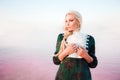 Young woman walking on Dead Sea with beautiful sky at pink sunrise Royalty Free Stock Photo